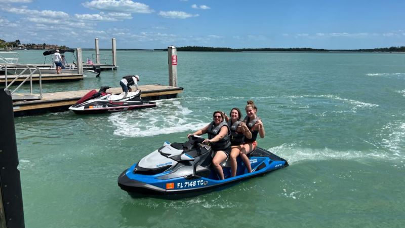 a group of people riding on the back of a boat in the water