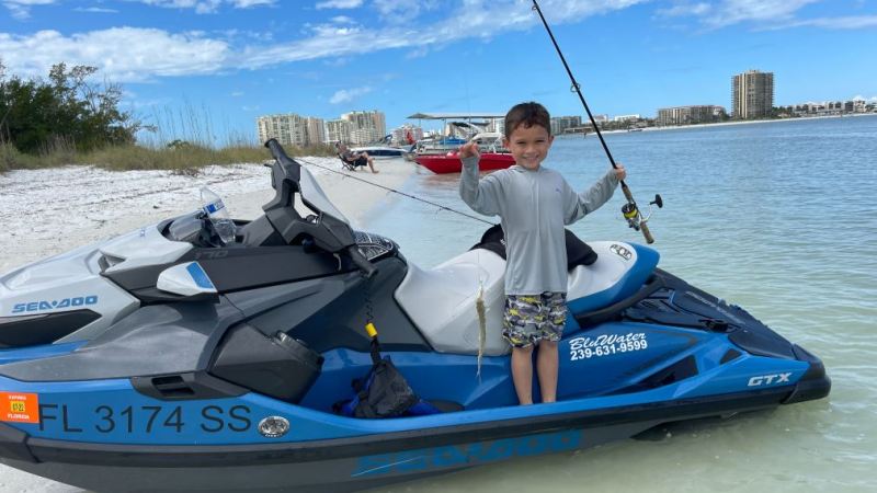 a man in a blue boat sitting next to a body of water
