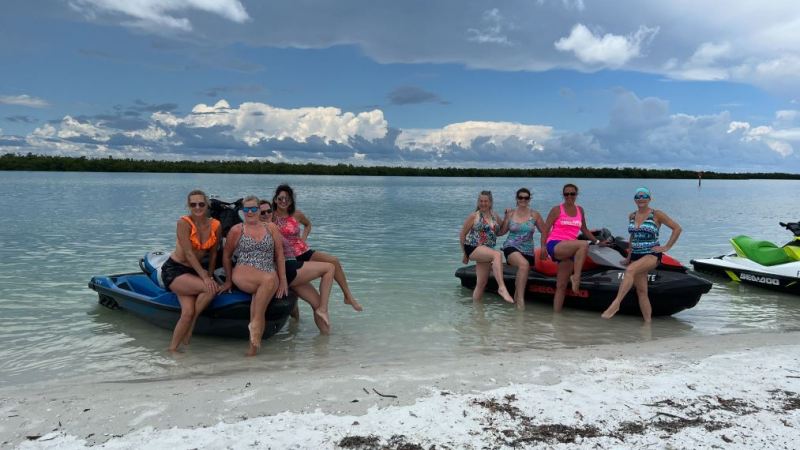 a group of people on a beach near a body of water