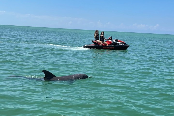 a man riding on the back of a boat in a body of water